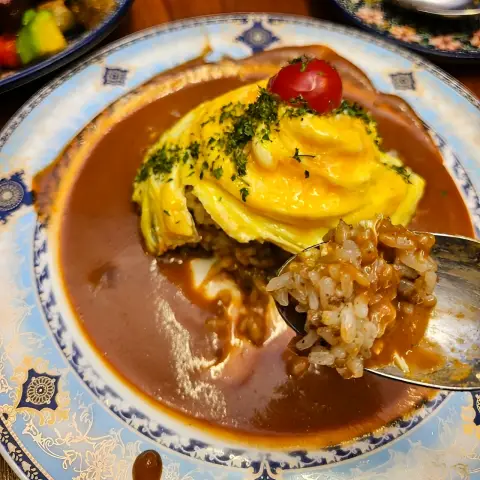 Swirl omurice with curry sauce and a spoonful of beef pilaf