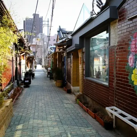 Sunny hanok alley with brick walls and mural art