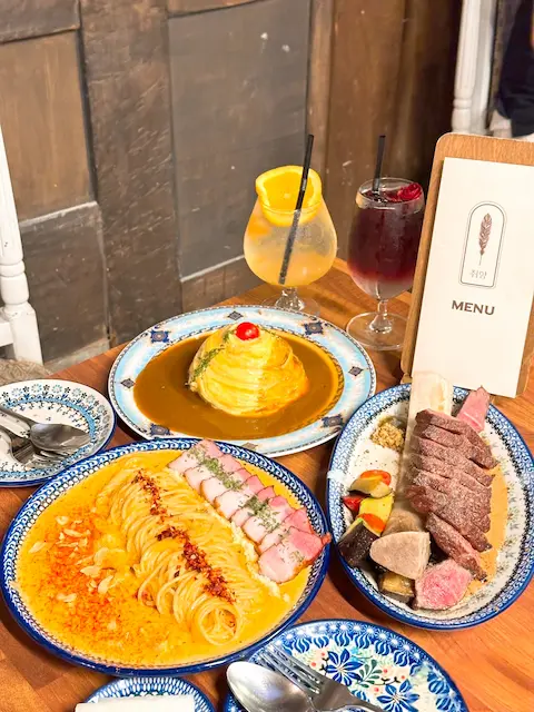 Full meal set with steak, pasta, omelet rice, and drinks at Ikseon Chwihyang