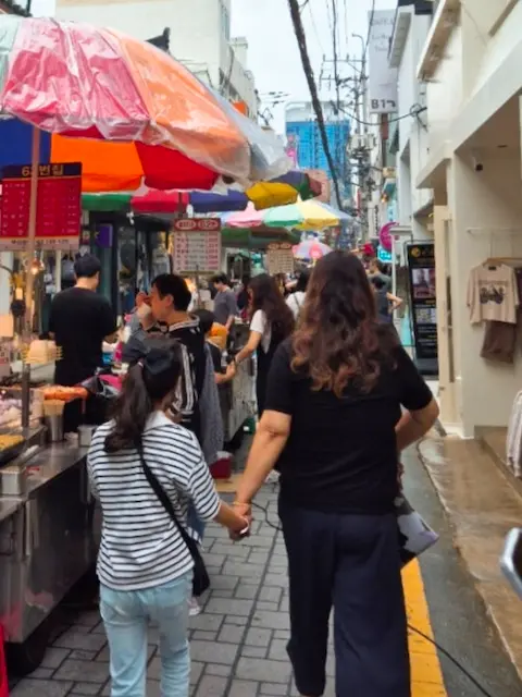 Colorful umbrellas and food stalls at Gukje Market side alley
