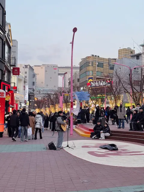 Street busker performing on a winter evening in Hongdae