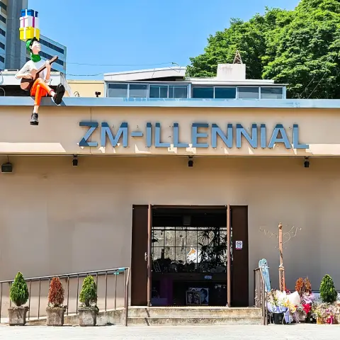ZM illennial front facade with rooftop statue and open entrance