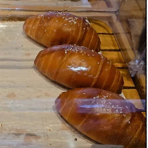 ZM illennial freshly baked salt bread loaves under a glass cover