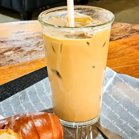 ZM illennial iced latte with straw and bread on the side