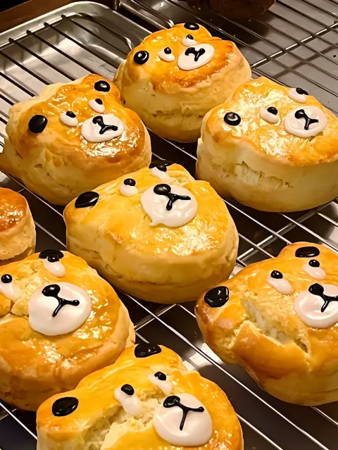 Golden brown teddy bear scones with glossy finish cooling on a rack