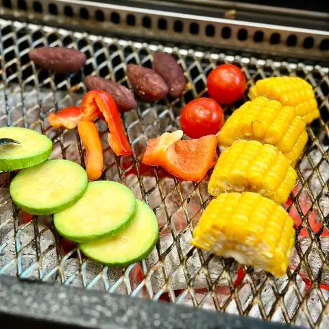 Grilled vegetables on the charcoal next to the eel