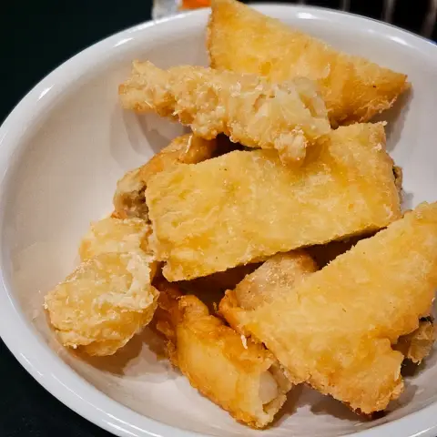 Plate full of crispy fried snacks including sweet potato and dumplings