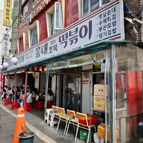 Exterior view of Jopok Tteokbokki Hongdae Branch with people dining outside