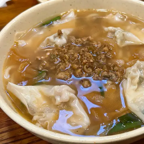 Bowl of kalguksu with minced meat and dumplings in chicken broth