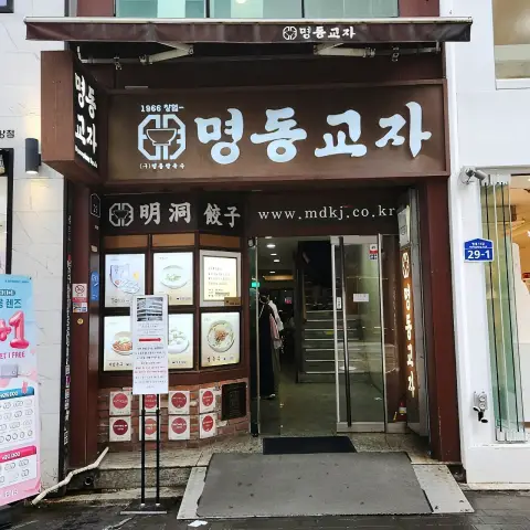 Main entrance to Myeongdong Kyoja with staircase and menu signage