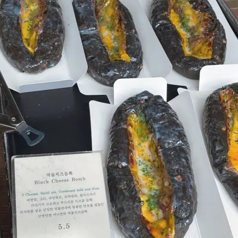 Black Cheese Bomb bread from the cafe onion anguk menu, made with squid ink and melted cheese