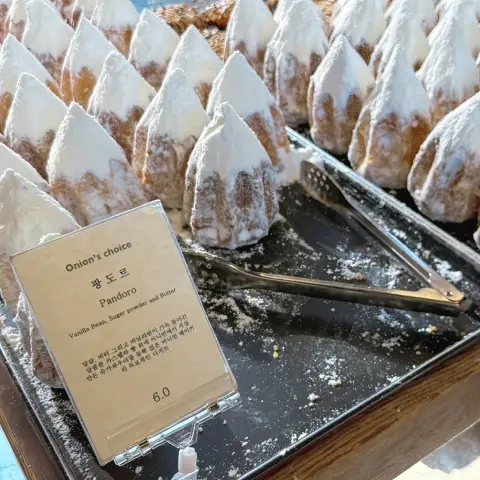 Cafe onion anguk menu highlight: Pandoro display with description tag and powdered topping