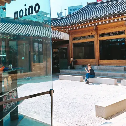 View of the hanok courtyard from inside Cafe Onion Anguk glass entrance