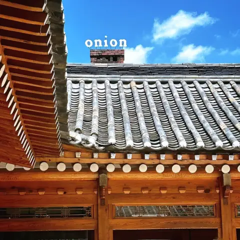 Traditional hanok roofline with Onion cafe sign above from the cafe onion anguk menu spot
