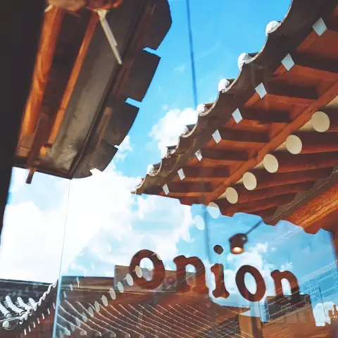 Cafe onion anguk menu enjoyed inside a hanok with a view of sky and tiled roof reflections