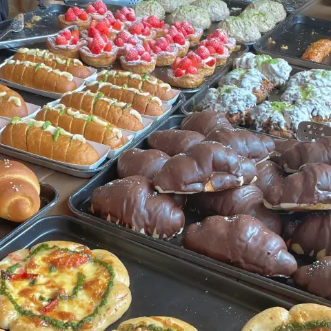 Wide view of trays featuring items from the cafe onion anguk menu including chocolate bread, strawberry pastries, and savory toast