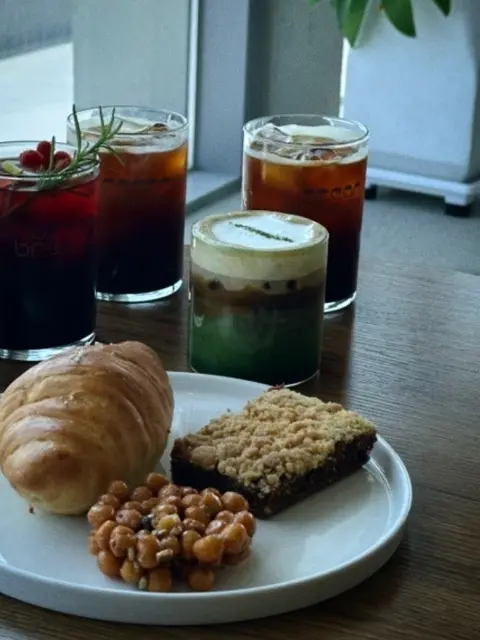 Cheongsapo cafe table with croissant, nut bar, and iced drinks