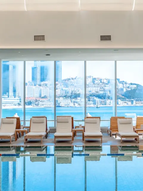 Loungers by the pool at Westin Josun Busan overlooking Haeundae skyline
