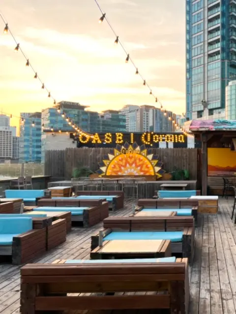 Rooftop seating with Oase and Corona signs lit up