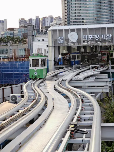Sky capsules curve into Mipo Station at Haeundae Blueline Park