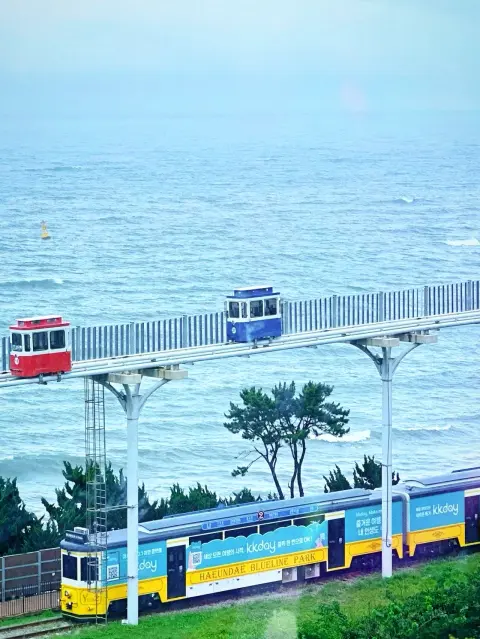 cheongsapo-skycapsule-ocean-view.webp Blue, red, and white sky capsules at Cheongsapo coast