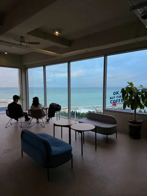 Lounge chairs by ocean view windows at Cheongsapo cafe