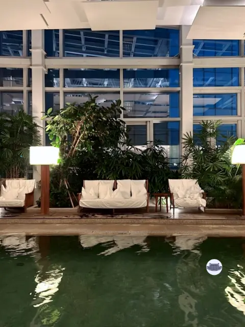 Poolside lounge with cozy chairs and plants inside Park Hyatt Busan
