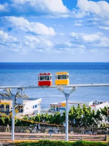 Red and yellow sky capsules riding parallel above the ocean