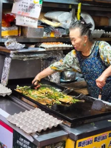 Elderly woman cooking at seafood pancake stall