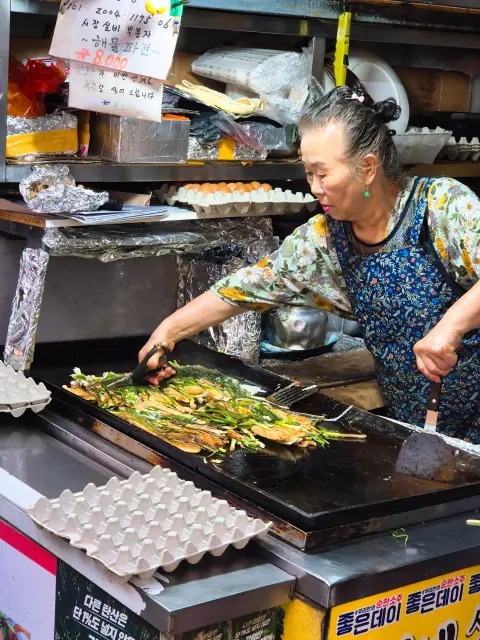 Elderly woman cooking at seafood pancake stall