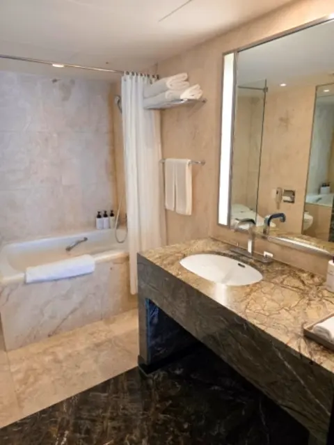 marble bathroom at paradise hotel busan with bathtub and amenities