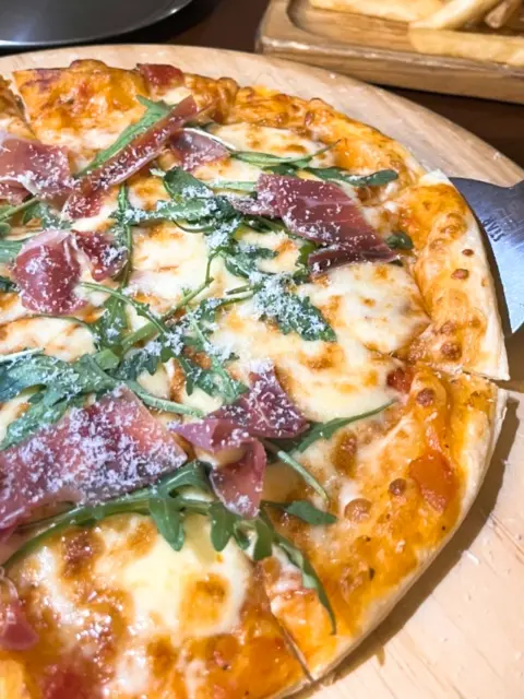 Prosciutto arugula pizza served fresh at Oase, a haeundae bar