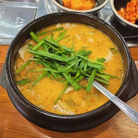 A colorful bowl of sundae gukbap topped with fresh chives