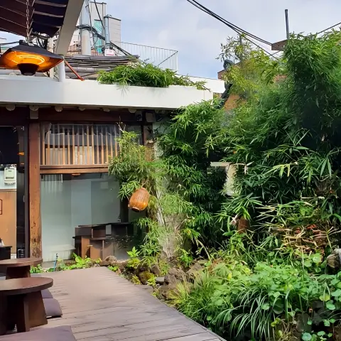 lush garden space surrounded by bamboo and wooden buildings