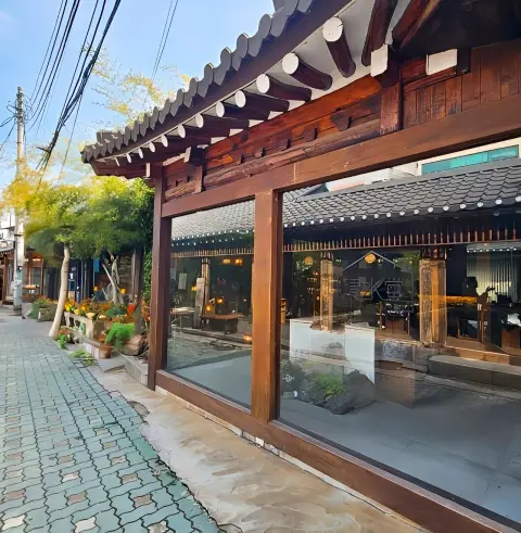 hanok building with large glass windows facing a stone pathway