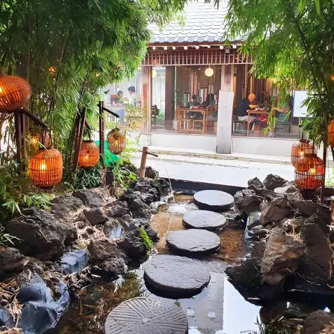 stone path leading to a traditional hanok with bamboo and lanterns