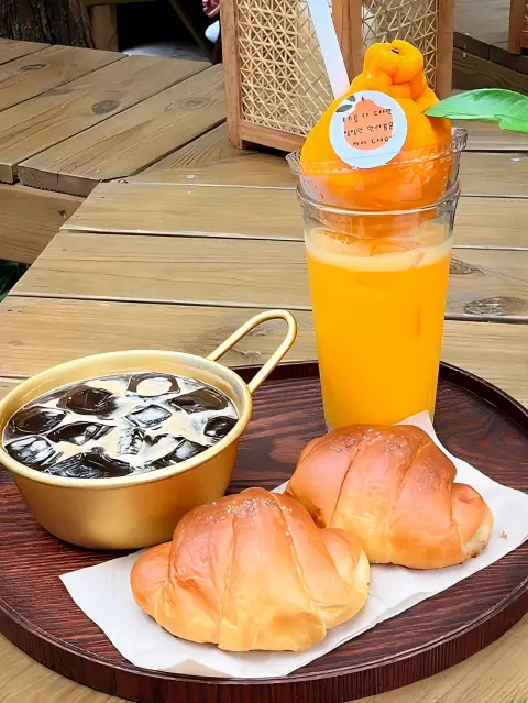 Jayeondo Salt Bread with iced coffee and hallabong juice on a tray