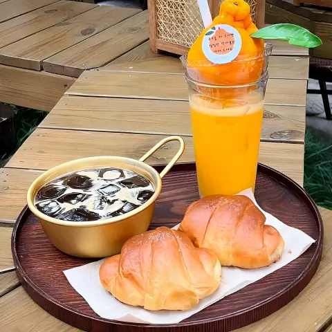 Jayeondo Salt Bread with iced coffee and hallabong juice on a tray