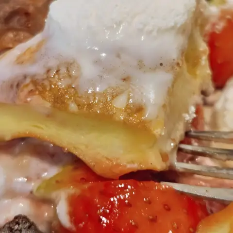 Spoonful of soufflé pancake and strawberry from a close-up angle