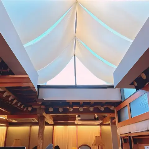 Sunlight filters through draped fabric ceiling in the café’s open roof