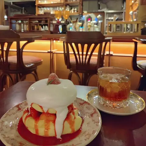 Pancake and iced tea on a cozy table inside a vintage-style café