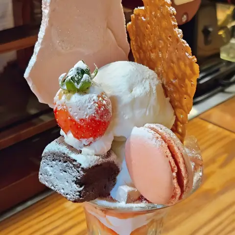 Zoomed-in view of parfait toppings with strawberry, brownie, and macaron