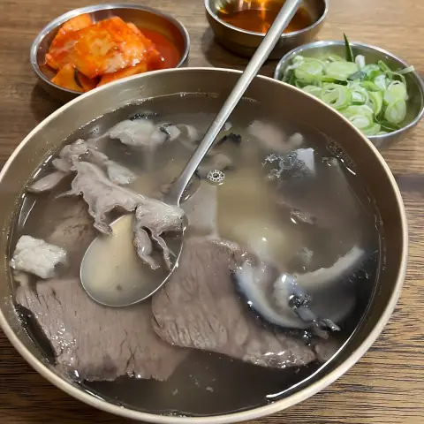 Close-up of Hadongkwan gomtang set with clear broth and beef slices