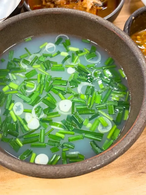 Halmae Jaecheopguk clam soup topped with chopped scallions and chives