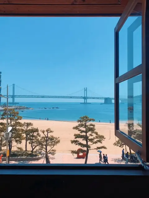 Open window at Nasari Sigdang showcasing Gwangalli Beach under blue skies