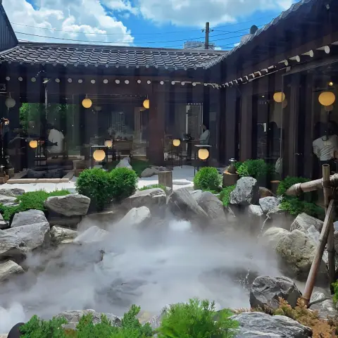 Oncheonjip courtyard pond with rocks, mist, and bamboo spouts