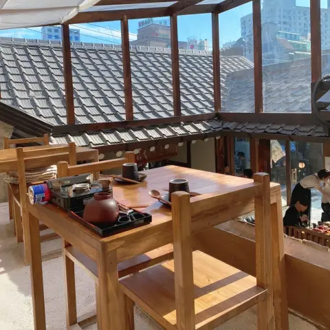 Second-floor seating overlooking Oncheonjip’s tiled rooftops