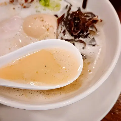 Spoonful of creamy chicken broth at Oreno Ramen Insa