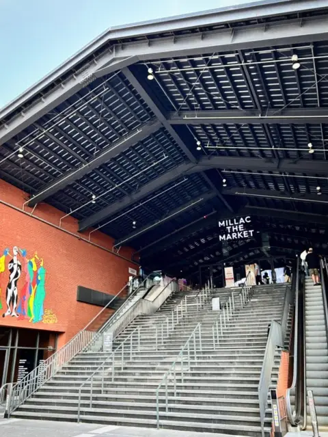 Millac The Market grand entrance with stairs and red brick facade