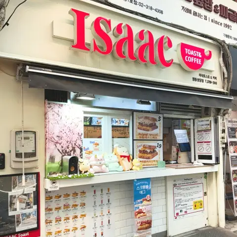 Isaac Toast Myeongdong street-side window with bright red sign and menu posters